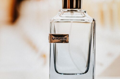 Elegant men's cologne bottle labeled "For Men" with warm amber bokeh light in the background