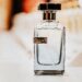 Elegant men's cologne bottle labeled "For Men" with warm amber bokeh light in the background