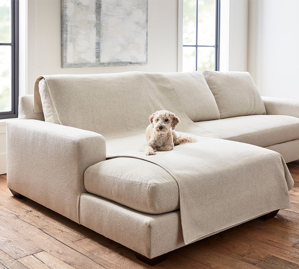 Neutral pet throw blanket draped over a sofa