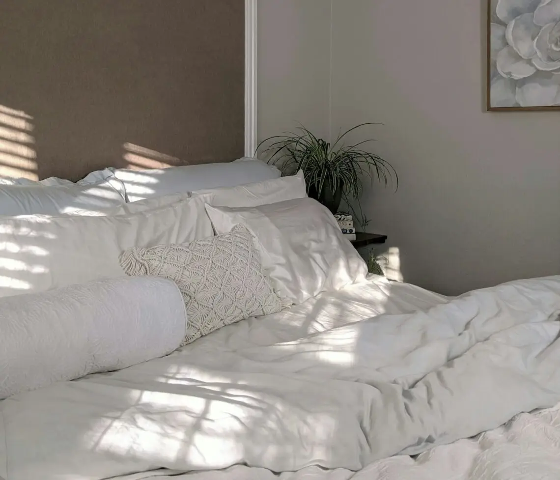 Neutral linen bedroom bathed in warm morning light