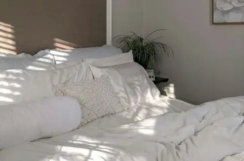 Neutral linen bedroom bathed in warm morning light