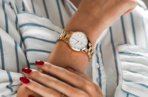 Woman's wrist wearing an elegant gold minimalist watch