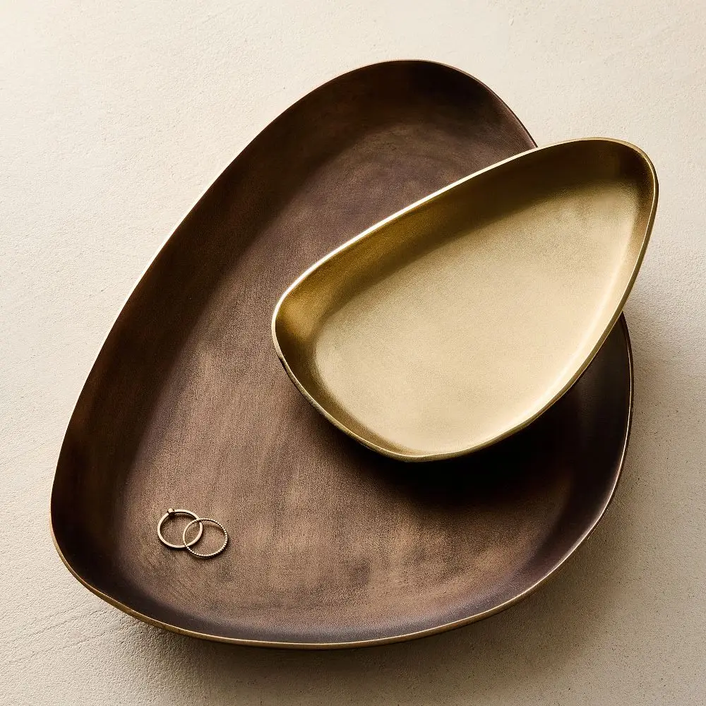 Organic metal trinket trays holding small nightstand items